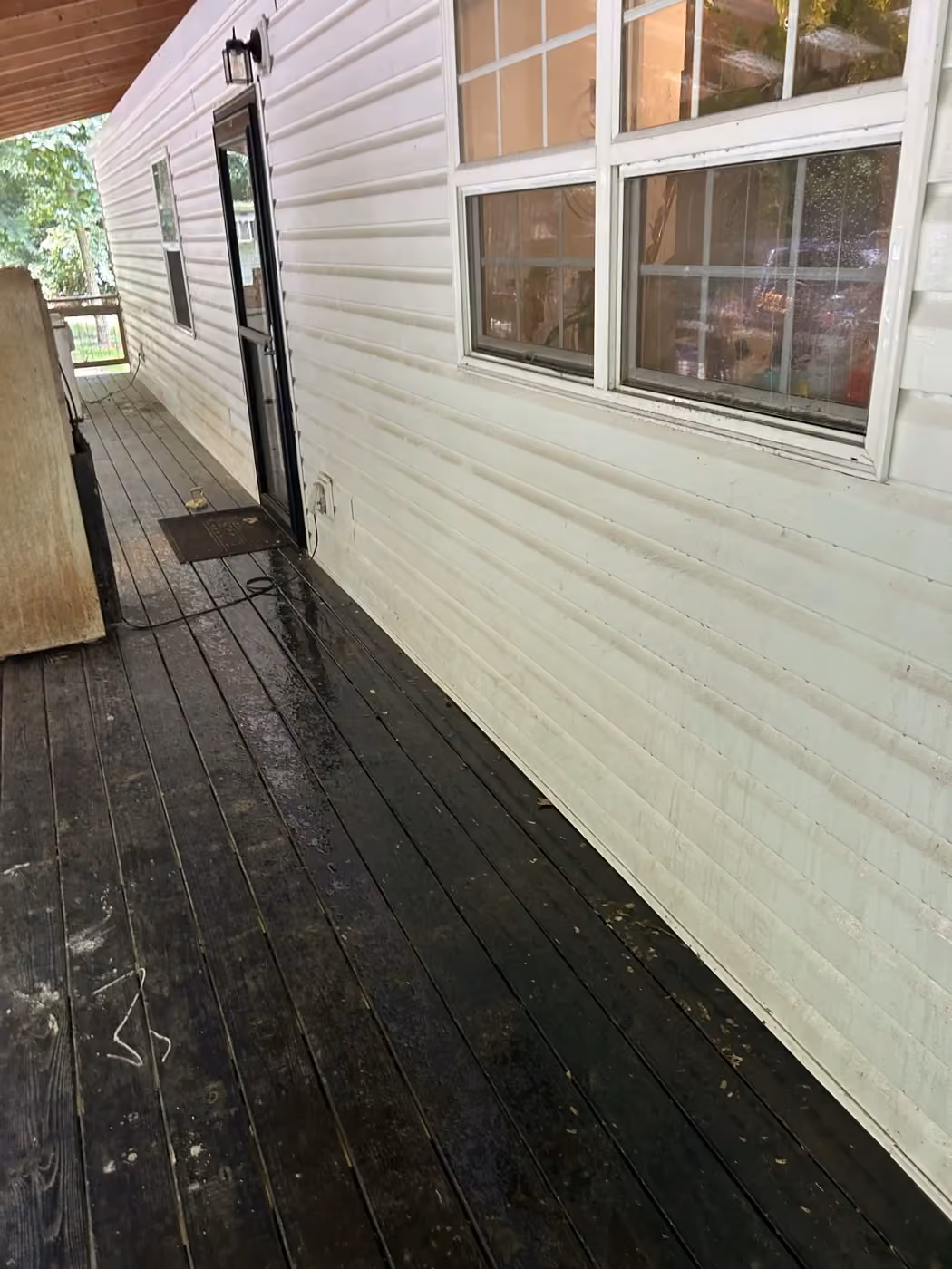Dirty siding along a Crossville-area porch during exterior cleaning.