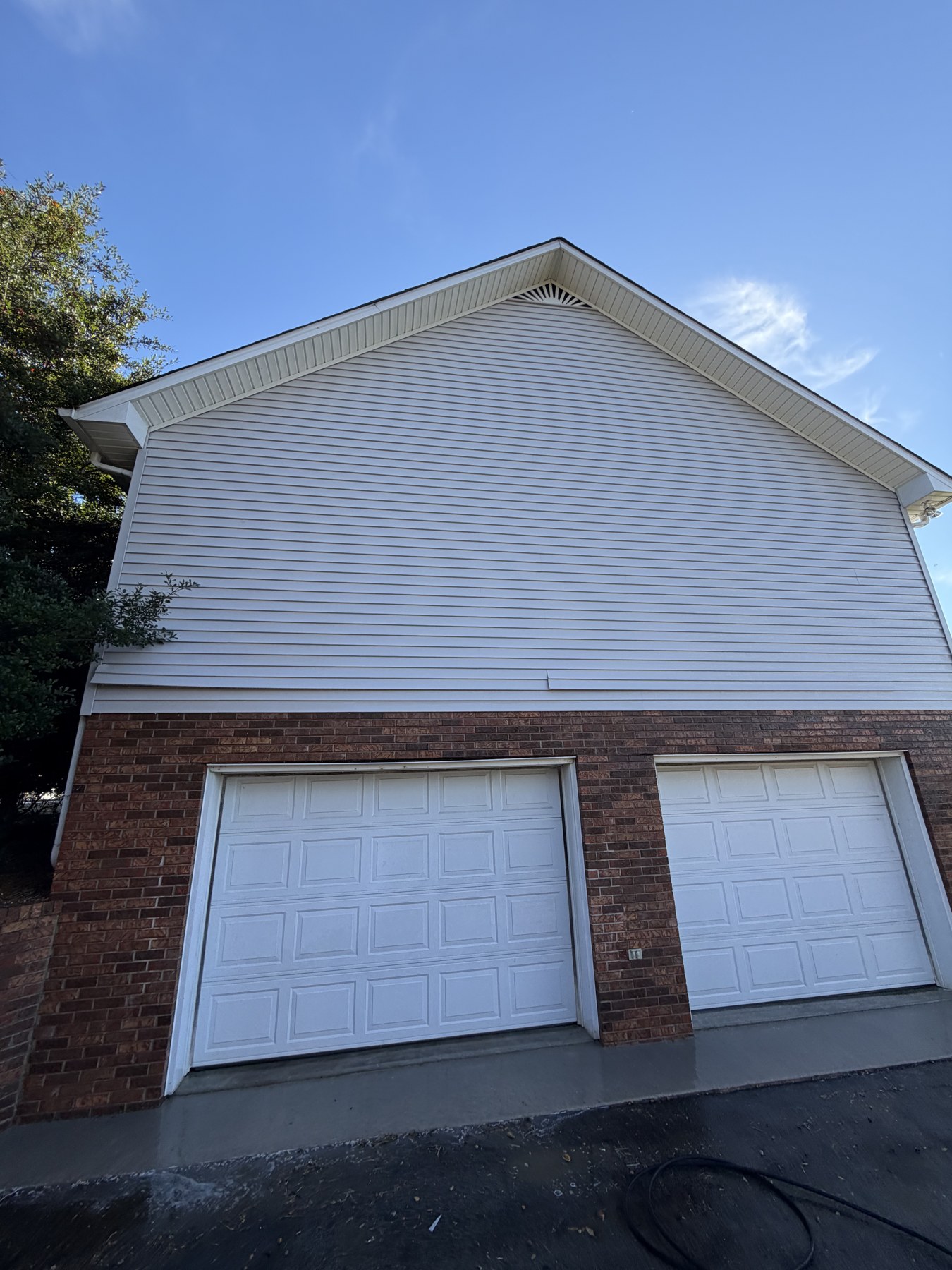 Clean white vinyl gable and garage after soft wash in Algood, TN