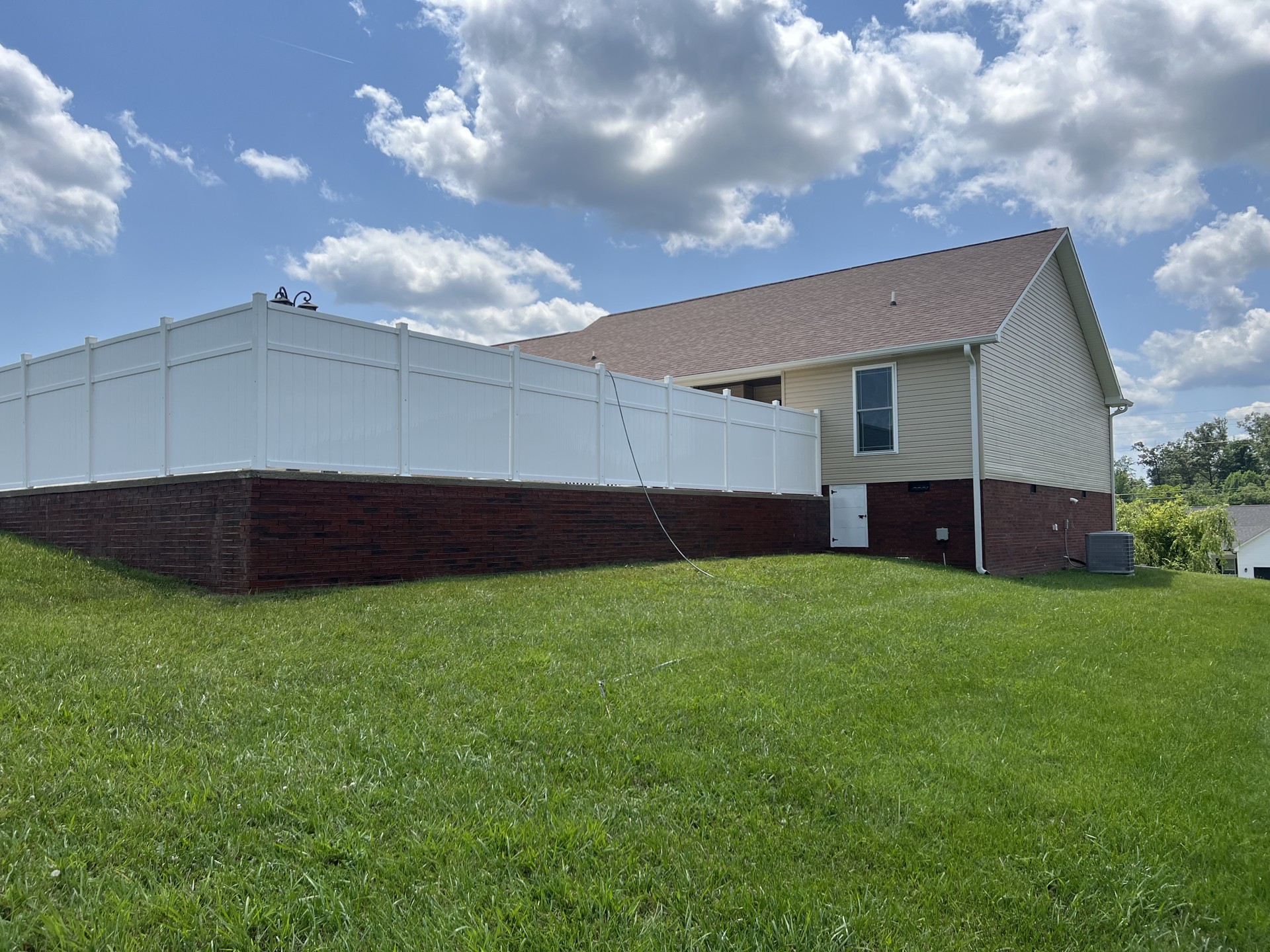 Clean siding and white vinyl fence after exterior cleaning in Cookeville, TN