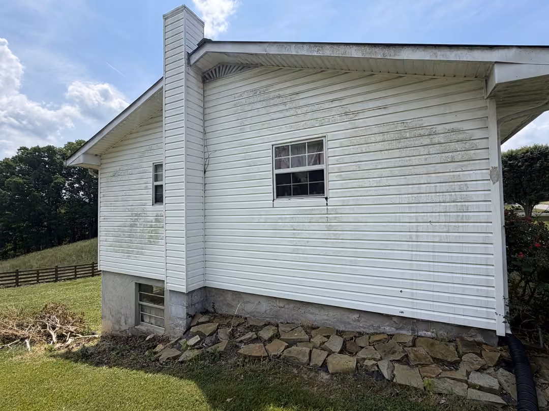 White vinyl siding with green algae and mildew before soft wash in Monterey, TN