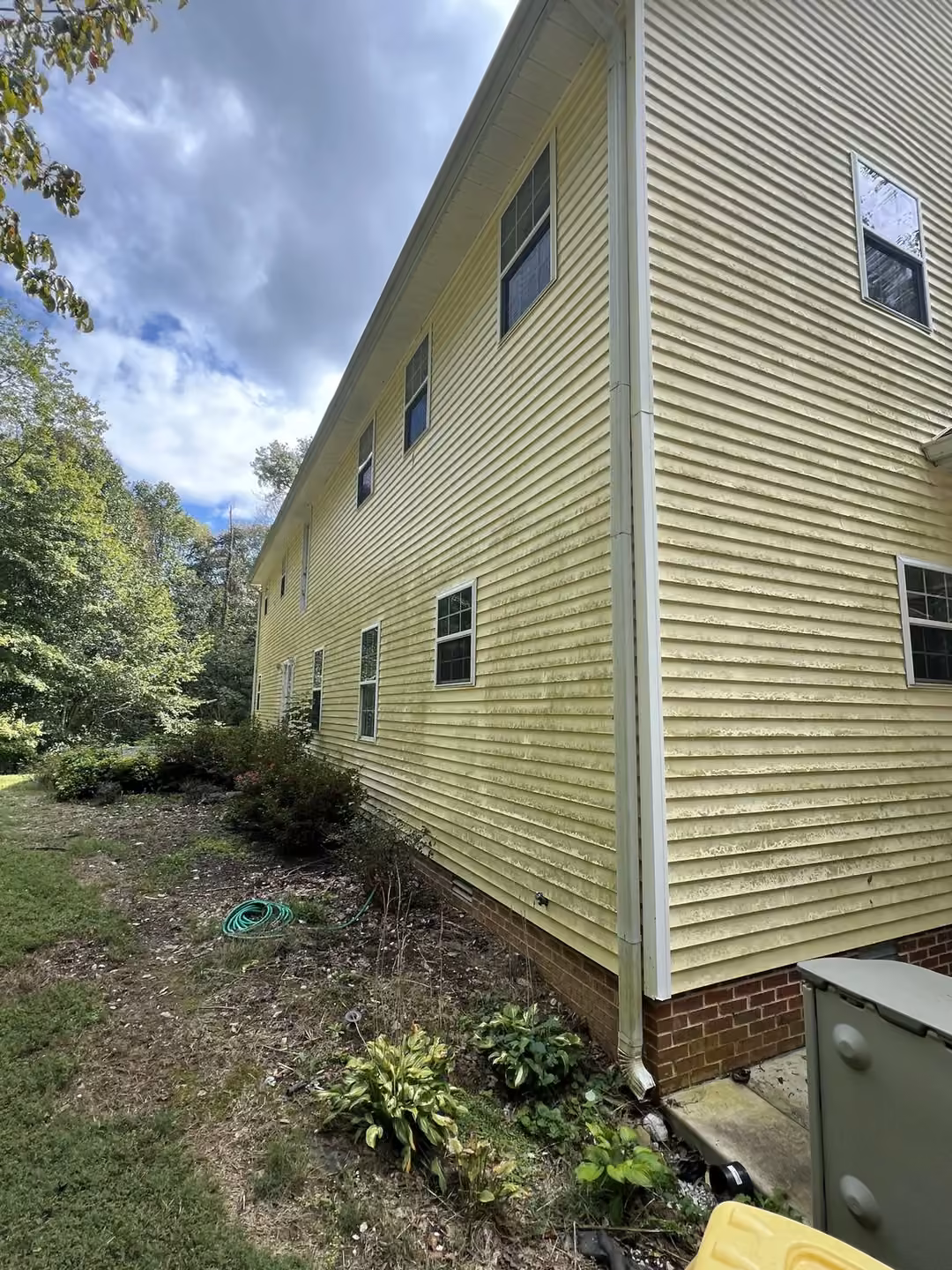 Dirty yellow siding before soft wash in Sparta, TN